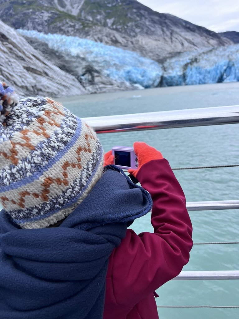 Child photographing a blue glacier from the Disney Wonder during an Alaska cruise