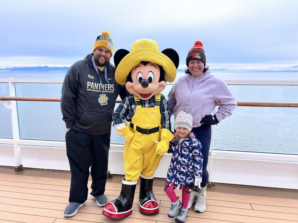 Family posing with Mickey Mouse aboard the Disney Wonder during an Alaska cruise