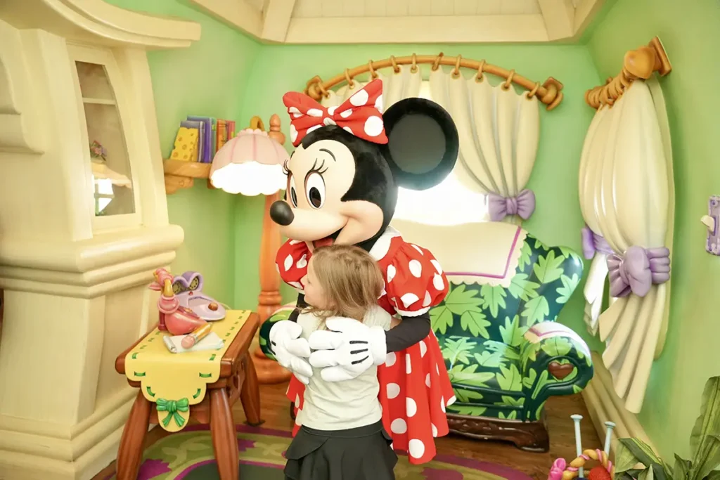 Young girl hugs Minney at Disneyland